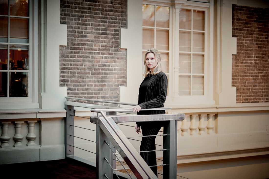 Standing at a railing by a window
