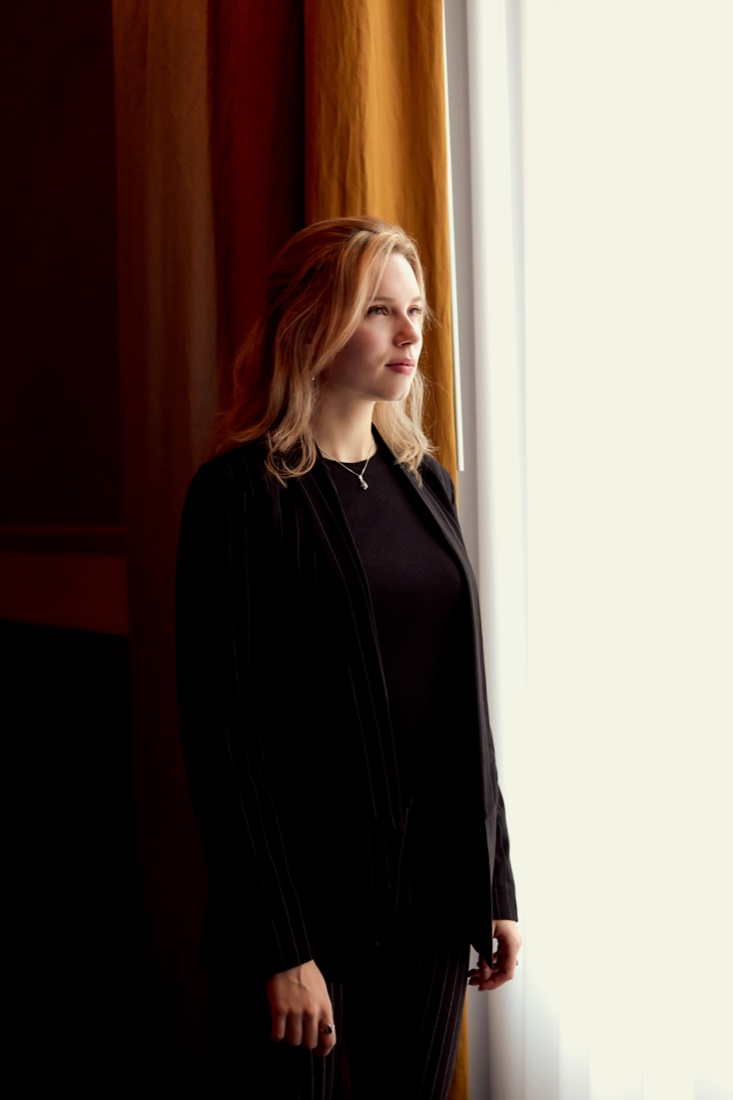 Standing by a window, backlit